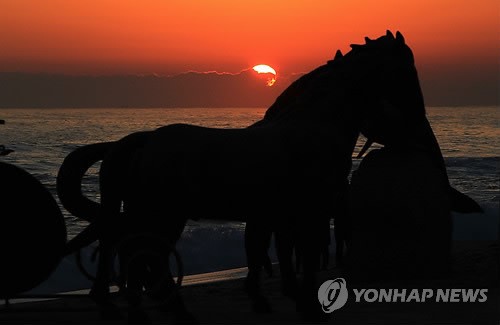 말 조형물과 일출