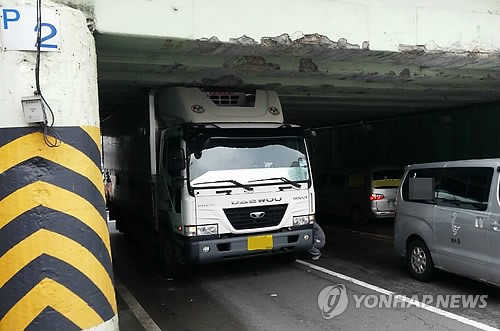 굴다리에 걸려 오도가도 못하는 화물탑차