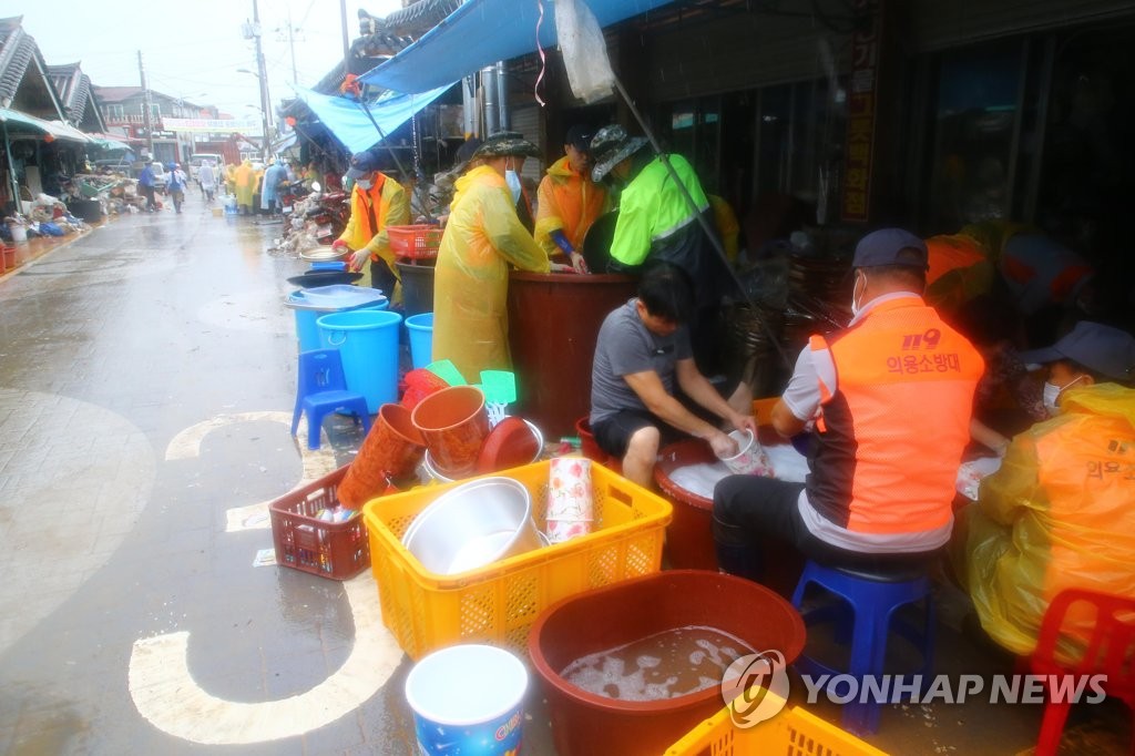 살수차 동원해 폭우 피해품 씻는 의용소방대원들