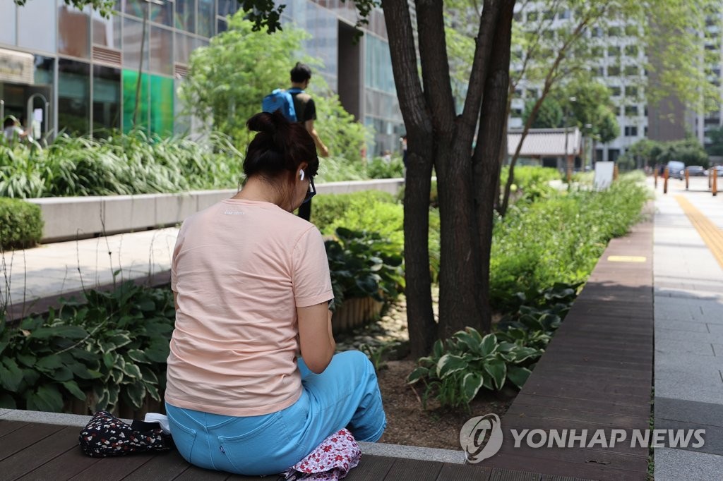 도심 속 나무 그늘 밑에서 피서