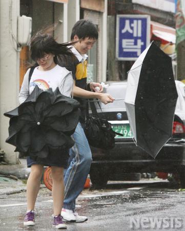 강풍에 뒤집히는 우산잡는 시민들