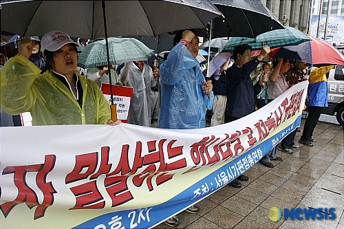 비속에서 투쟁 외치는 가판점상인들
