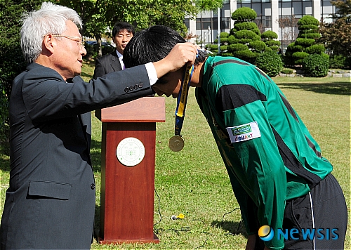 축구부에 금메달 걸어주는 김진규 총장