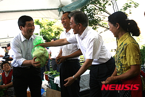찜통 더위 속 풍물시장서 장보는 세 사람