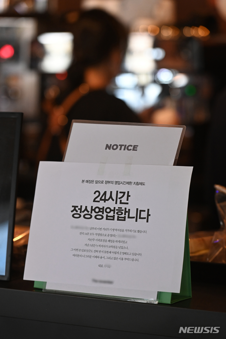 24시간 정상영업 안내문 붙은 카페