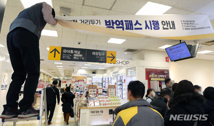 방역패스 효력 일부 정지, 시행 현수막 회수하는 대형마트 관계자