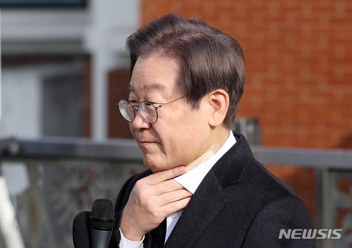 목 만지는 이재명 대표