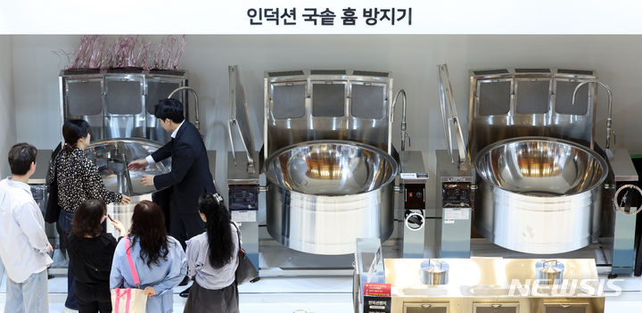 인덕션 국솥 흄 방지기 살펴보는 관람객들