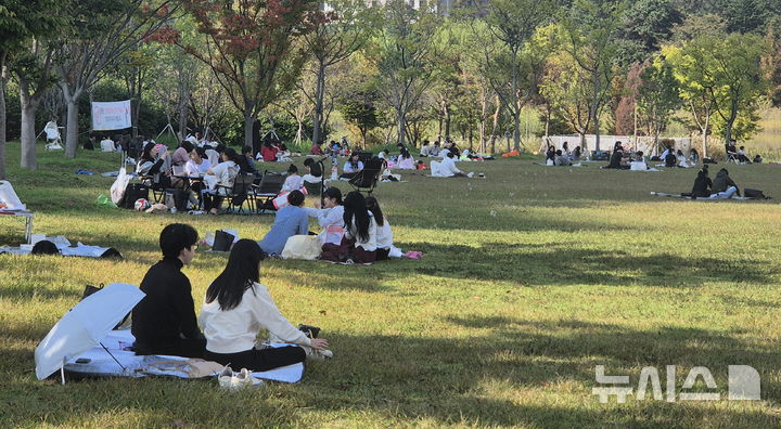 선선한 나무 그늘 아래 피크닉 즐기는 시민들