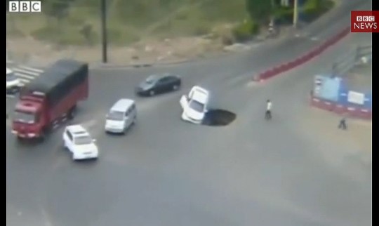 ‘우물쭈물하다’ 교차로 싱크홀에 빠진 車