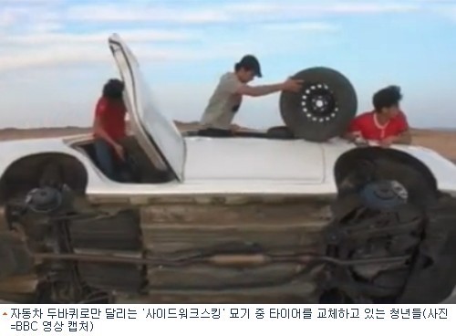 두바퀴로 달리는 차에서 타이어 갈기 엽기 묘기