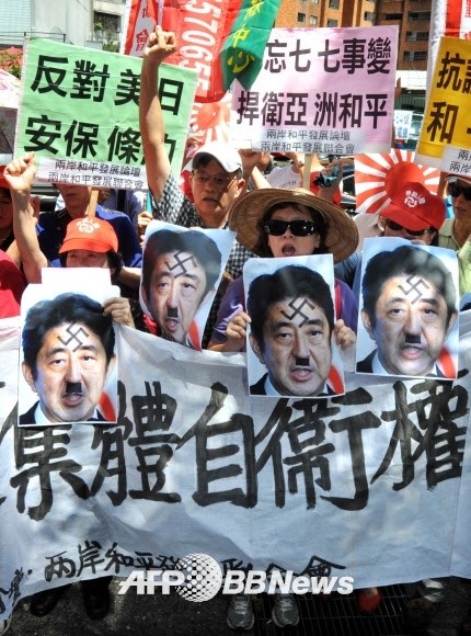 갈기갈기 찢긴 군국주의 상징 ‘히틀러’로 묘사된 아베 일본 총리 사진