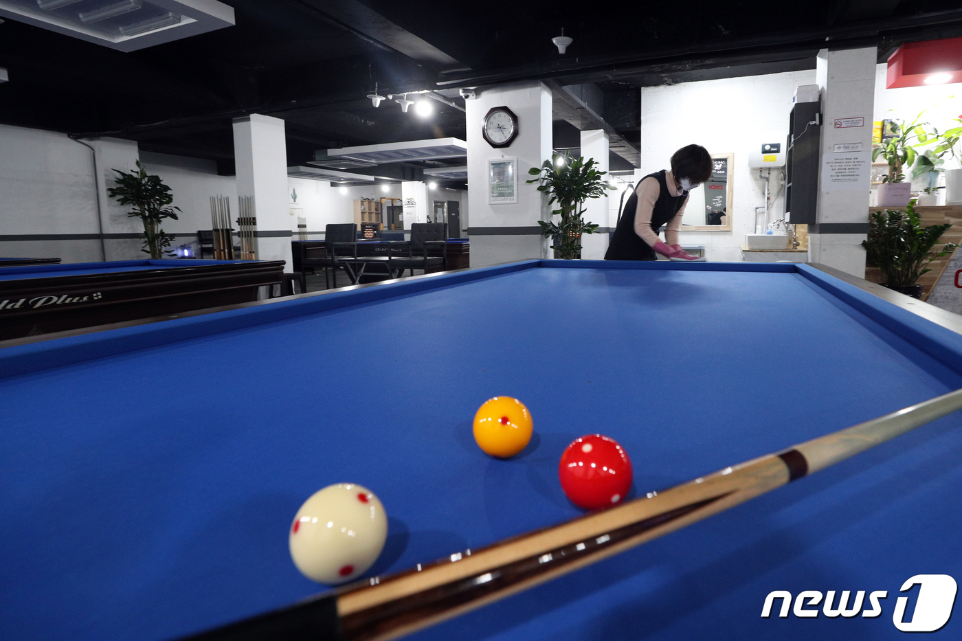 테이블 닦으며 다시 올 손님 기다리는 당구장 점주