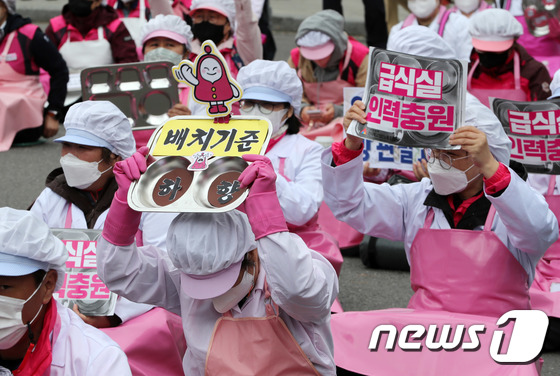 식판 들고 구호 외치는 급식노동자들
