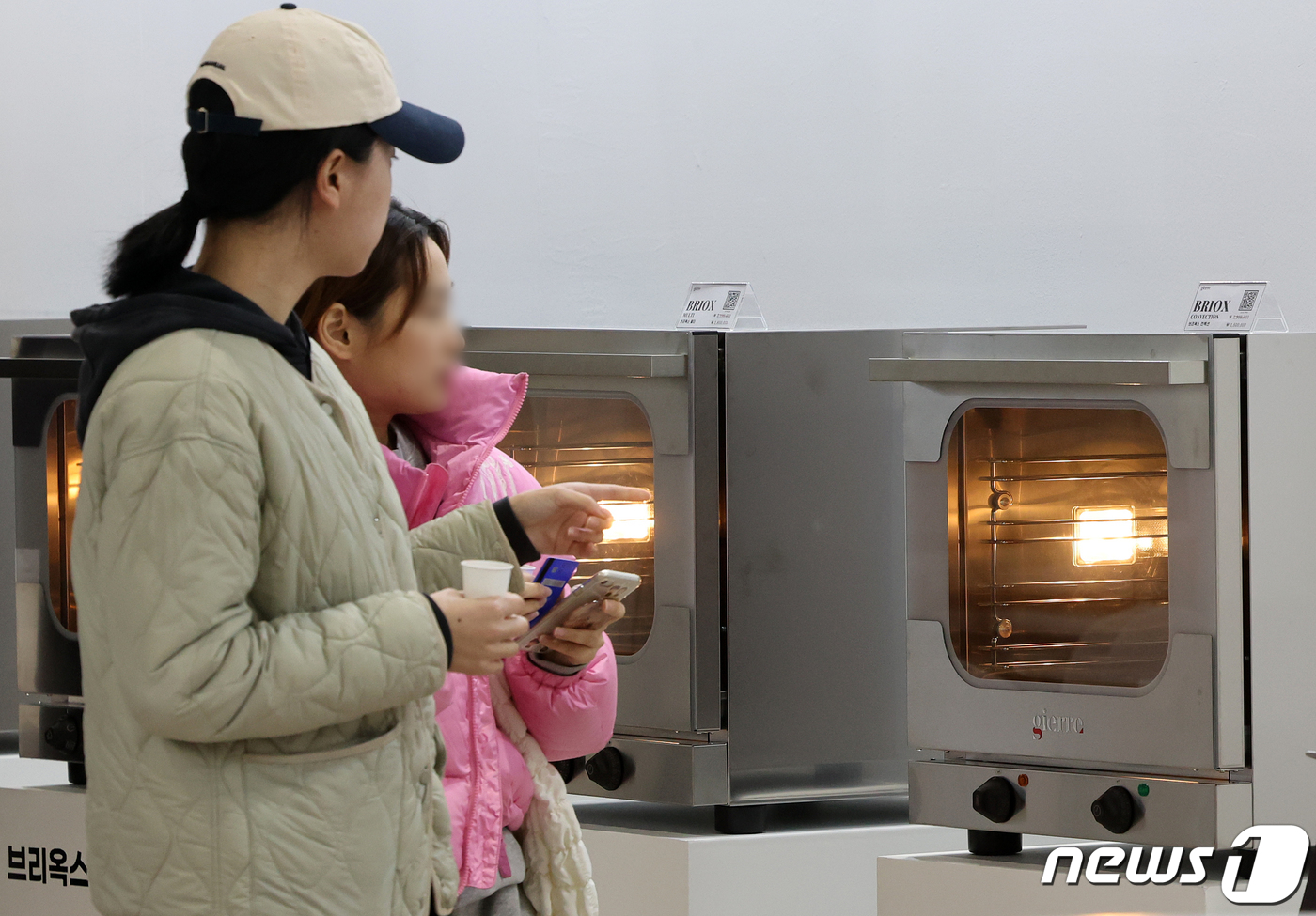 베이커리 기기 살펴보는 관람객들