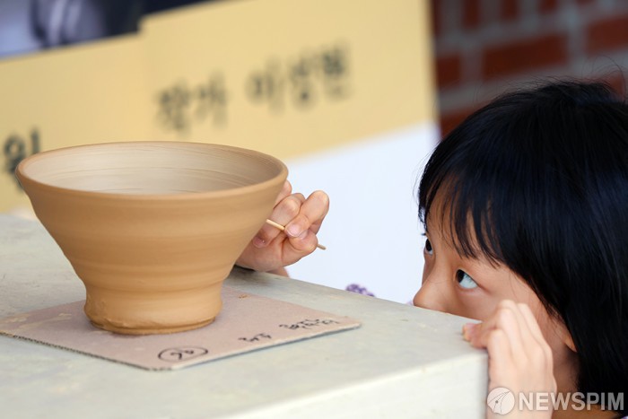 도자기에 자신의 그림 그리는 어린이