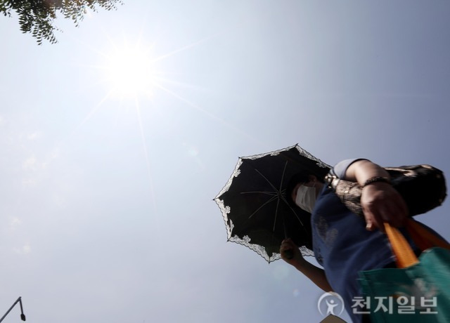 [천지포토] 양산으로 햇빛 가리며 이동하는 시민