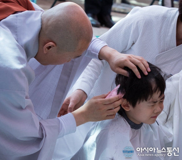 동자승 삭발식, 머리락이 잘리고 있는 한 아이