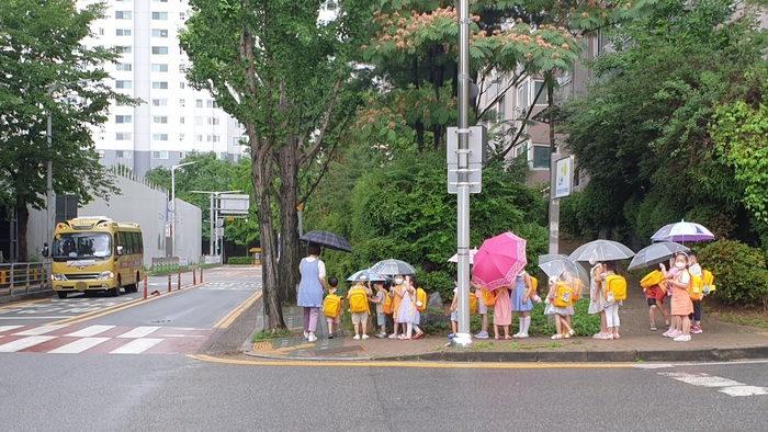 [포토] 우산 쓰고 옹기종기 버스 기다리는 어린이집 아이들