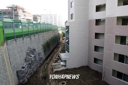 고도제한 피하려 땅 파 지은 아파트